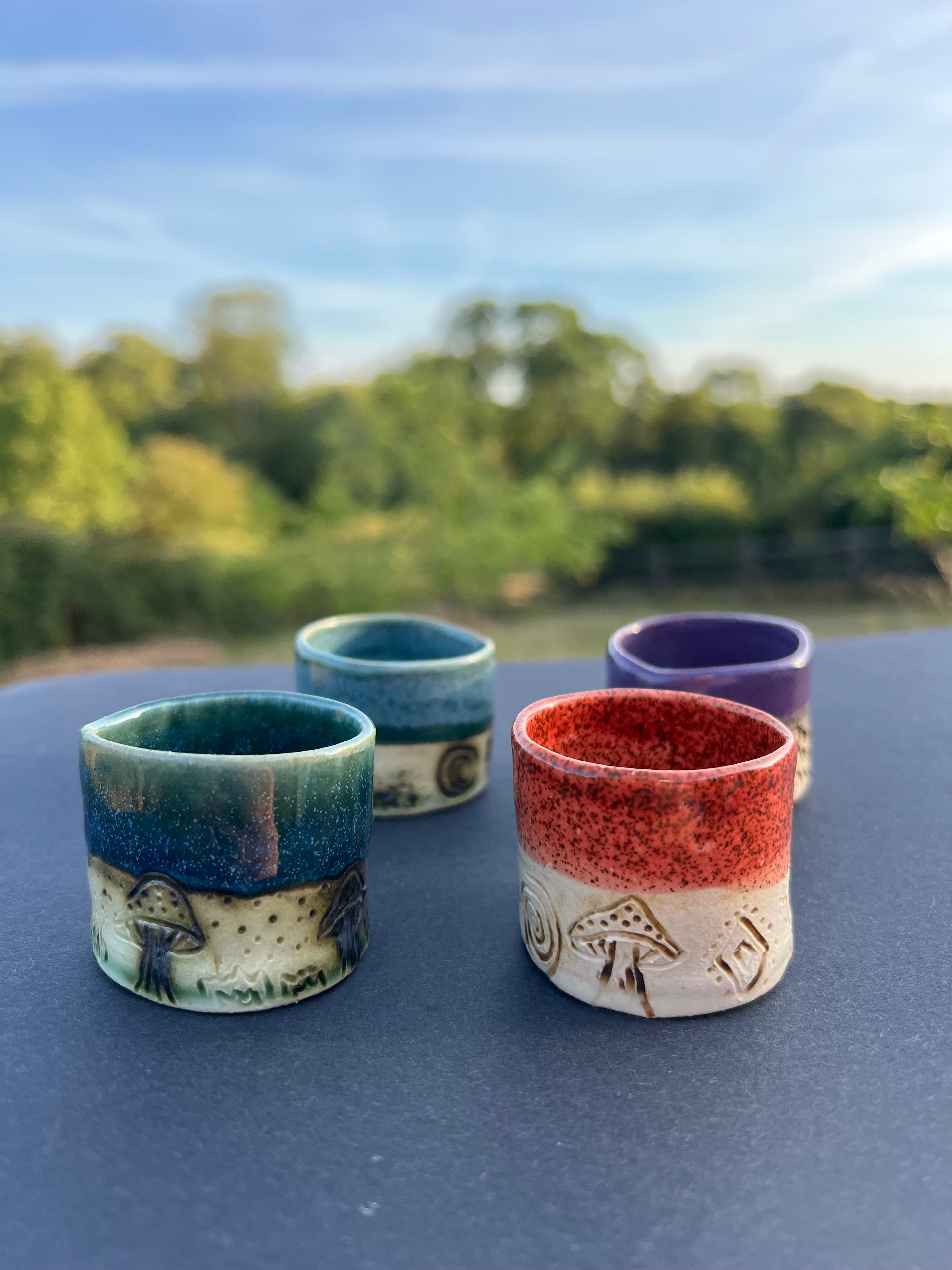 Collection of handmade ceramic cups with colourful glazes
