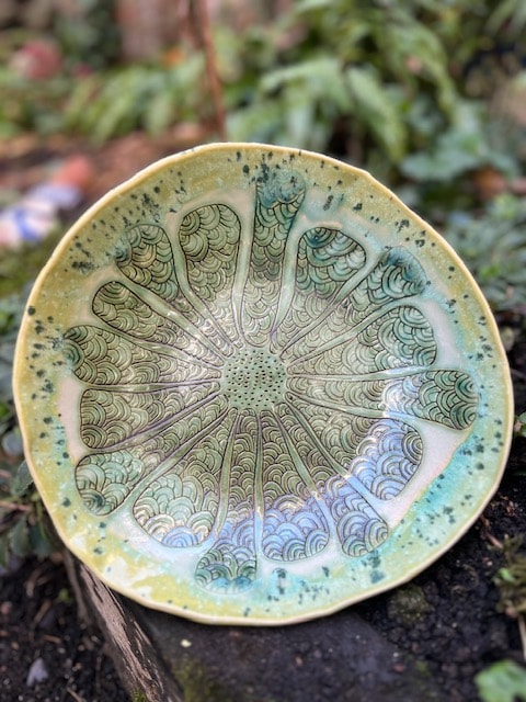Handmade ceramic bowl with intricate green splatter flower pattern