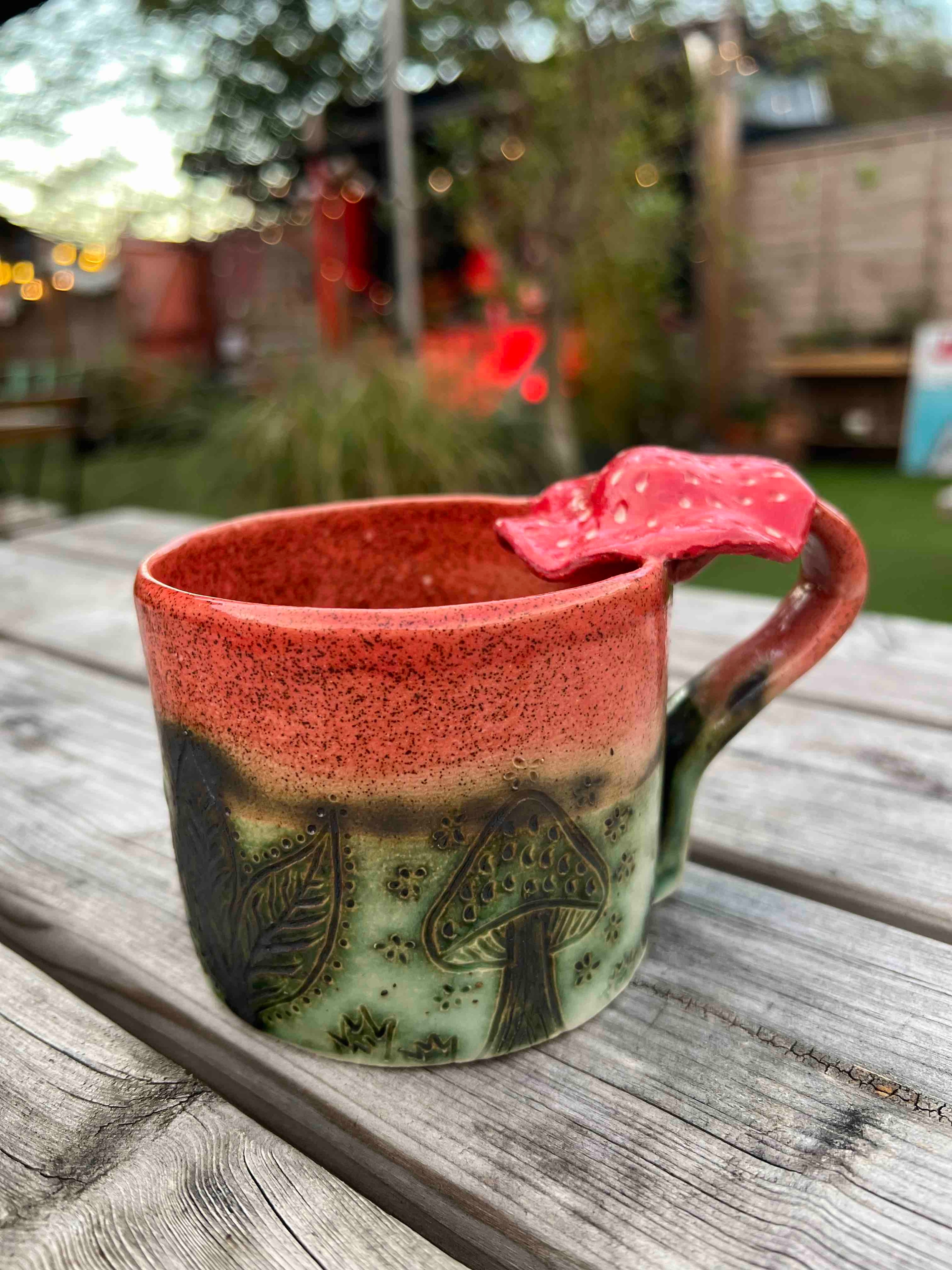 Handmade ceramic mug with floral detail and mushroom handle